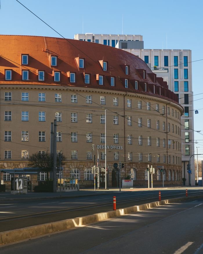 Elegant curved facade of a modern office building under a clear sky in an urban setting.